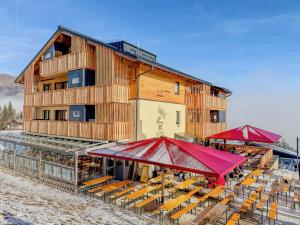 a building with tables and umbrellas in the snow at Bockblick Top 4 in Weisspriach +14 photos