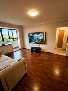 a room with a bed and a television on the wall at Central plaja Neversea in Constanţa