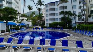 ein Schwimmbad mit blauen Liegestühlen und ein Hotel in der Unterkunft Hotel Acapulco Malibu in Acapulco + 41 Fotos