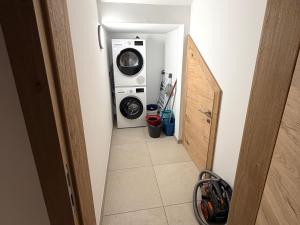 a hallway with a washing machine and a washer at Grebenzen 66 in Sankt Lambrecht