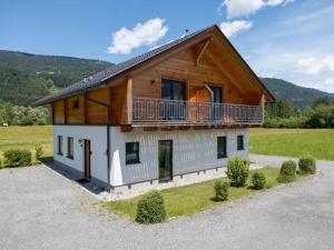 a wooden house with a balcony on top of it at Rattendorf 23B in Rattendorf