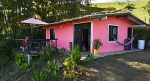 a pink house with a porch and a patio at Finca La Preciosura in El Peñol