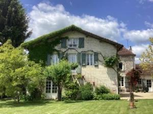 a large stone house with a green yard at Petit Vingne in Édon