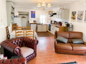 a living room with two leather couches and a kitchen at Petit Vingne in Édon