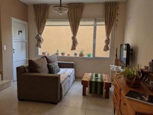a living room with a couch and a window at Casa Valdés in Puerto Pirámides