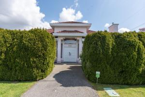 a white garage with two large hedges in front of it at Home Base Quiet Queen Rooms in Richmond