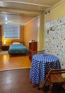 a bedroom with a bed and a table with a table sidx sidx sidx at Cabañas Deisy in Valdivia