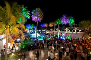 a crowd of people walking around a pool at night at Kimpton Surfcomber Hotel by IHG in Miami Beach +142 photos
