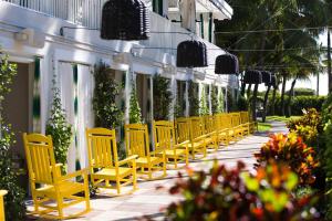 a row of yellow chairs on a sidewalk at Kimpton Surfcomber Hotel by IHG in Miami Beach