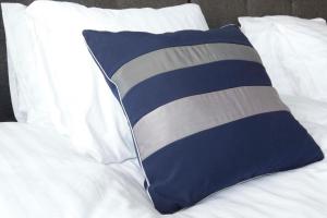 ワルシャワにあるMagnetic Studio Odkrytaのベッドの上に青と白のストライプ枕