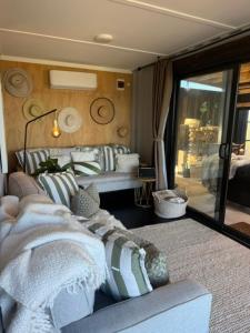 a living room with a bed and a couch at Rangitoto Retreat Raglan in Te Akau