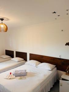 two beds in a bedroom with two towels on them at Pousada Numei de Jeri in Jericoacoara