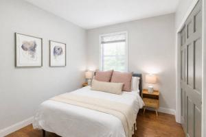 a white bedroom with a bed and two lamps at Sky Deck | Downtown in Boston