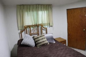 a bedroom with a bed with a window and pillows at Hotel 7 Rooms in Guadalajara