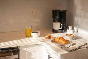 a kitchen counter with a cup of orange juice and croissants at Sky Deck | Downtown in Boston +7 photos