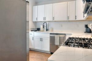 a kitchen with white cabinets and a stove at Sky Deck | Downtown in Boston