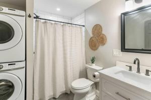 a white bathroom with a washer and a sink at Sky Deck | Downtown in Boston