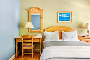 a bedroom with two beds and a desk with a mirror at Southampton Long Island Hotel in Southampton +30 photos