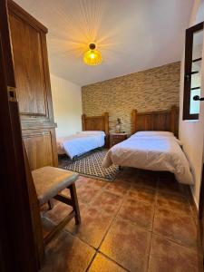 a bedroom with two beds and a chair at AT El Cordel in Nogales