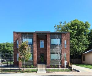 a brick house with a fence in front of it at Xscapecation Oasis III in Tulsa