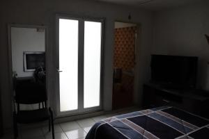 a bedroom with a sliding glass door and a television at Hotel 7 Rooms in Guadalajara