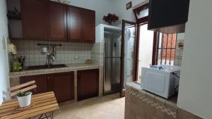 a kitchen with wooden cabinets and a stainless steel refrigerator at La Dimora di Gianna in Palermo