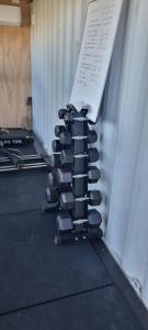 a pile of dumbbells stacked on top of a wall at Rangitoto Retreat Raglan in Te Akau +27 photos