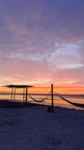 a picnic table on the beach at sunset at La Bahia de Makale in Pisco