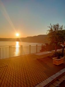 a sunset on a deck with a view of the water at Scilla Central Rooms in Scilla