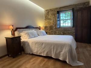 a bedroom with a large bed with a stone wall at Paco d'Anha in Viana do Castelo +70 photos