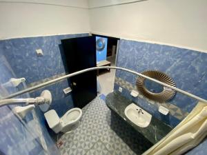 a bathroom with a toilet and a sink and a mirror at HotelMariaAngela in Dzuiché