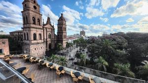 a view of an old building with tables and chairs at Hotel Pascana Plaza in Santa Cruz de la Sierra