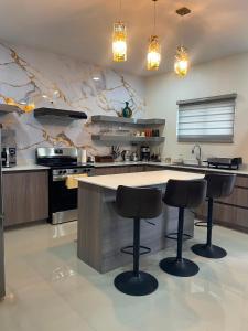 a kitchen with a counter with three bar stools at Suite Seven in Mount Pleasant +6 photos