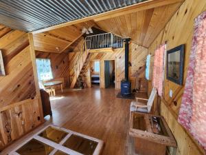 a large living room with wooden walls and wood floors at Beaver Creek Guest Ranch in Blue