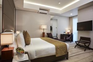 a hotel room with a bed and a desk at Mandarina Colombo in Colombo
