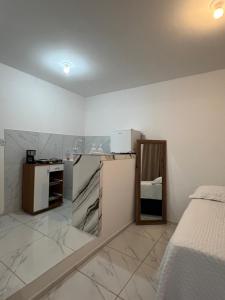 a room with a kitchen with a refrigerator and a bed at Apartamento da Kenia in Canoa Quebrada