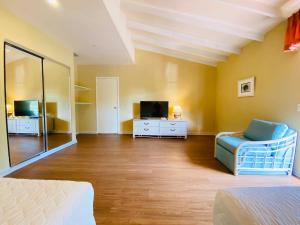 a living room with a couch and a tv at Aparthotel La Quinta in Santa Cruz de la Sierra