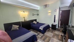 a hotel room with two beds and a television at A12 MAX Suite Cocina Terraza Empresas Equipos de Trabajo 1-2-3-4 PAX in Cuautitlán Izcalli