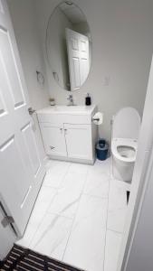 a white bathroom with a toilet and a mirror at Entire condo in White Rock, Canada in White Rock