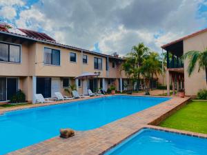 a large swimming pool in front of a house at Aparthotel La Quinta in Santa Cruz de la Sierra