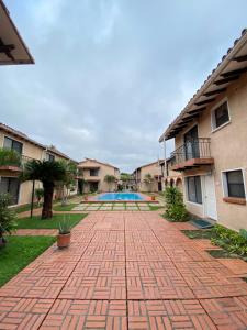 a brick walkway with a pool in a courtyard at Aparthotel La Quinta in Santa Cruz de la Sierra