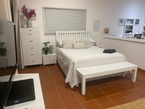 a bedroom with a bed and a tv in it at Ciara's Cottage CC'S in Illawong