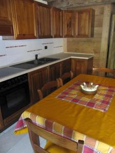 una cocina con mesa de madera y una cocina con mesa de mesa en Appartamento Le Jardin CIR VDA Aymavilles 0009, en Aymavilles