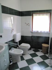 La salle de bains est pourvue de toilettes et d'un lavabo. dans l'établissement Appartamento Le Jardin CIR VDA Aymavilles 0009, à Aymavilles
