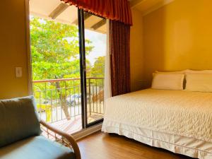 a bedroom with a bed and a balcony with a window at Aparthotel La Quinta in Santa Cruz de la Sierra