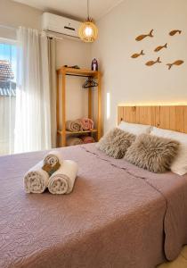 a bedroom with a bed with towels and a window at Villa 61 | Hospedagem – Praia de Armação – Beto Carrero in Penha
