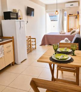 a kitchen and living room with a table and a refrigerator at Villa 61 | Hospedagem – Praia de Armação – Beto Carrero in Penha