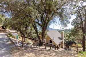 a house with a tree in front of it at Riverfalls Retreat in Oakhurst