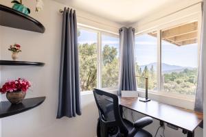 a home office with a desk and a window at Riverfalls Retreat in Oakhurst +4 photos