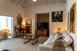 a living room with a white couch and a tv at Villa Madame in Saint Martin